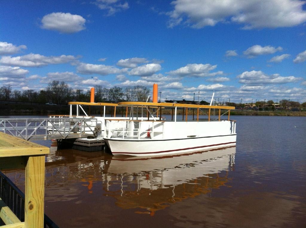Custom Evans river tour boat docked at yellow pier